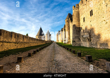 La rue antique entre les murs d'une fortification médiévale sous un ciel bleu nuageux Banque D'Images