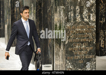 Singapour - février 27, 2011:un homme d'agréables promenades le long de la construction de l'assurance en Asie. Cet immeuble de grande hauteur est situé sur Finlayson Green. Banque D'Images