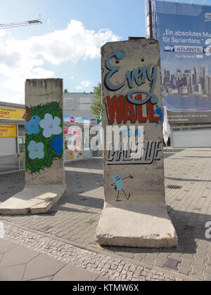 Les graffitis sur le mur de Berlin à Checkpoint Charlie sont devenus une forme d'expression pendant la guerre froide, symbolisant la résistance et la division de Berlin est et Ouest. L'œuvre colorée reflète les tensions politiques de l'époque. Banque D'Images