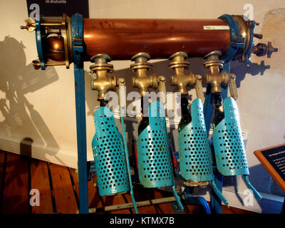 Cette image montre une machine de remplissage de bouteilles de bière, un élément essentiel de l'équipement dans l'industrie brassicole. Il est utilisé pour remplir efficacement les bouteilles avec de la bière pendant le processus d'emballage, assurant le contrôle de la qualité et la vitesse. Banque D'Images