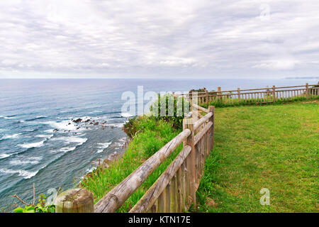 Vue sur la mer de la haute-côte. Au premier plan un fragment d'une clôture en bois, le ciel nuageux avec des nuages, d'un vert éclatant de l'herbe. Journée d'été dans n Banque D'Images