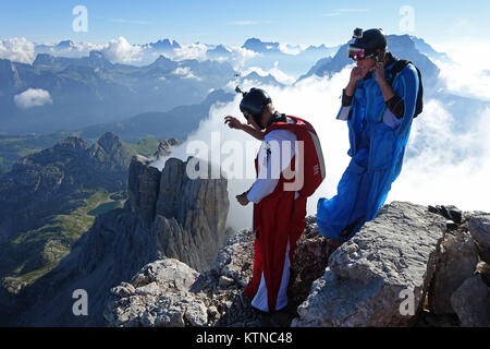 Ces cavaliers BASE Wingsuit se préparent à la sortie pour leur saut. Il est impressionnant de voir le courage de franchir la falaise. Banque D'Images