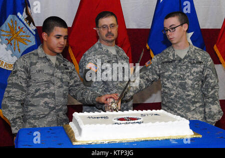 LATHAM , NY - New York Garde nationale d'un membre de la 1re classe Rafael Lopez (à gauche), Sgt. 1re classe Michael Lieber (milieu) et Pvt. Ryan Potosky (droite) utiliser un sabre de cérémonie pour couper un gâteau pour célébrer le 377e anniversaire de la Garde nationale ici le 13 décembre. Lopez, 19 ans, et Potosky, 18 ans, tous deux engagé l'année dernière alors que Lieber, 60, est le plus ancien soldat servant dans la Garde Nationale de New York. Lieber, qui prend sa retraite à la fin de décembre, a servi de 1975 à 1985 , réinscrit en 2003 et a servi en Irak environ deux ans plus tard. Lieber, de Schenectady, New York) a également reçu la médaille du service med Banque D'Images