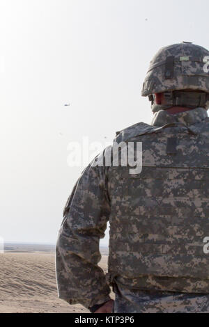 Le colonel Albert J. Ricci Sr., commandant de la 42e Brigade d'aviation de combat, regarde un AH-64 Apache exploité par l'attaque 4-227ème Bataillon de Reconnaissance, 1re Division de cavalerie, maintenant sous la 42e CAB, cercles après une attaque conjointe exécuter au cours d'un exercice de tir réel partenariat entre l'armée américaine, l'US Air Force, et la Force aérienne koweïtienne quelque part dans le sud-ouest de l'Asie, le 18 décembre 2013. La 42e CAB, New York Army National Guard, arrivé récemment au Koweït et a pris le commandement de l'aviation de l'armée d'actif dans la région, dans le cadre de l'opération Enduring Freedom. (U.S. Photo de l'armée par la CPS. Harley Jelis/Re Banque D'Images