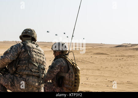 Blackhawks UH-60 d'une Co., 3-142ème Assault Helicopter Company, et A. Co., 1-189ème brigade aérienne d'appui général, 42e Brigade d'aviation de combat, de l'approche pour lancer une attaque aérienne avec des soldats d'un Co., 1-67ème régiment de blindés, 2-4ème Division d'infanterie lors d'un exercice d'entraînement du 15 au 28 mai 2013, à l'extérieur du camp Buehring, le Koweït. La 42e CAB, New York, la Garde nationale est actuellement déployé à l'étranger pour l'exploitation d'aéronefs à voilure rotative à l'appui de l'opération Enduring Freedom. (U.S. Photo de l'armée par la CPS. Harley Jelis/libérés) - au Camp Buehring Koweït. Banque D'Images