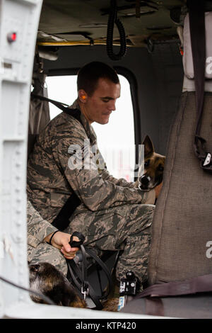 Tech. Le Sgt. Andrew Montgomery, un groupe de militaires de l'Armée de l'air de chien, console son chien à l'intérieur Diesel une armée UH-60 Blackhawk hélicoptère exploité par une compagnie, 3e Bataillon, 142e Assault Helicopter Company, 42e Brigade d'aviation de combat, au cours d'un exercice de familiarisation pour les chiens, le 10 janvier 2014, quelque part dans le sud-ouest de l'Asie. Les chiens de travail peuvent être transportés par hélicoptère rapidement et efficacement à l'endroit où ils sont nécessaires une fois qu'ils se sentent à l'aise avec l'avion. La 42e CAB, New York, la Garde nationale est actuellement déployé à l'étranger dans le cadre de l'opération Enduring Freed Banque D'Images