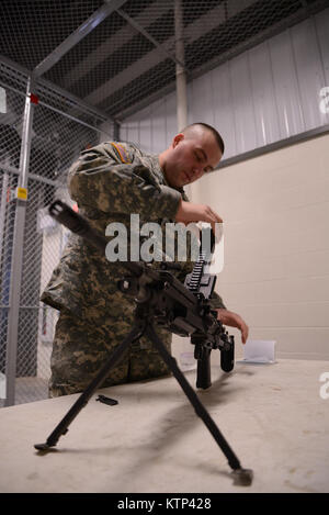 La CPS. Bryan Plunckett, trompettiste avec la 42e Division d'infanterie, une bande bandes M249 light machine gun tout en participant à un concours de meilleur guerrier à Fort Drum N.Y., 10 janvier. Un Plunckett, Buffalo, N.Y., résident, a été l'un des sept soldats du 42e bataillon de l'Administration centrale l'Administration centrale et à la concurrence. (Photo par le Sgt. J.p. Lawrence, 42e Division d'infanterie, PAO). Banque D'Images