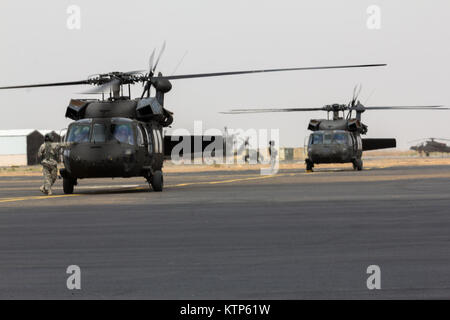 L'ARMÉE AMÉRICAINE UH-60 Black Hawk de la Compagnie A, 3e bataillon du 238e bataillon de l'aviation d'appui général, 42e Brigade d'aviation de combat, se préparer pour le décollage avec des aéronefs exploités par les forces terrestres de l'Arabie Royal 1er Bataillon, 3e Groupe d'Aviation pour une agression de l'air au cours de l'effort de l'amitié et fer à repasser Hawk 14 le 12 avril 2014, près de Tabuk, Arabie saoudite. Fer à Repasser Hawk et l'amitié 14 Les forces de l'armée américaine participent à partir de la 42e CAB, New York, la Garde nationale et la 2e Brigade Combat Team, 4e Division d'infanterie, et la masse de l'Arabie Saoudite et les forces de l'aviation. Plus de semaines de pratique les deux armées l'accent o Banque D'Images