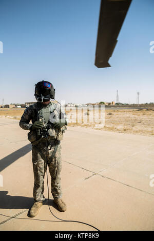 La CPS. Giles Dunlop, chef d'équipe avec l'entreprise C, 1er Bataillon, 214e Air Ambulance, 42e Brigade d'aviation de combat (cabine), surveille son vol's UH-60 Black Hawk comme il se prépare à décoller avant un exercice de récupération du personnel avec une force aérienne koweïtienne hélicoptère Puma SA 330 le 19 juin 2014, au Koweït. 42e CAB et forces koweïtiennes effectuent régulièrement des joint aviation partenariats pour accroître leur capacité à répondre à toute urgence. La 42e CAB, New York, de la Garde nationale de l'armée est déployée au Koweït dans le cadre de l'opération Enduring Freedom. (New York) La Garde nationale de l'armée photo par le Sgt. Harley Jelis/relâché Banque D'Images