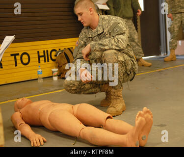 La CPS. Craig Berg, de Norwich, New York, un fantassin de la société Delta 2-108ème régiment d'infanterie, examine une victime de blessures à une station au cours de la 27e Brigade Combat Team's Best Warrior Competition Samedi, 7 février, 2015 à Hancock Field à Syracuse, New York. (U.S. Photo de l'armée par le Sgt. Jonathan Monfilletto) Banque D'Images