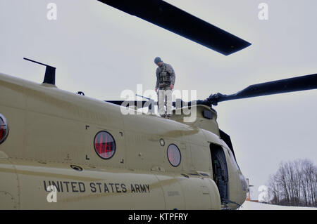 SYRACUSE, NY - Le Sergent de l'armée. Landaur Mike termine une vérification de la sécurité d'un CH-47F Chinook le 14 mars 2015. Le s.. Landaur CH-47F est un chef d'équipage de la Compagnie B, 3e bataillon du 126e, basé à l'aviation de l'aviation de l'armée et de soutien à l'Aéroport International de Rochester. 30 aviateurs du 274e Escadron d'opérations d'appui aérien (ASOS), basé à Hancock Field Air National Guard Base et l'équipage de l'armée se sont entraînés ensemble pour la première fois. La formation portait sur la Finale de l'attaque conjointe (ou contrôleur JTAC) aviateurs de la 274e ASOS effectuant fréquemment de familiarisation de l'hélicoptère CH-47 Banque D'Images