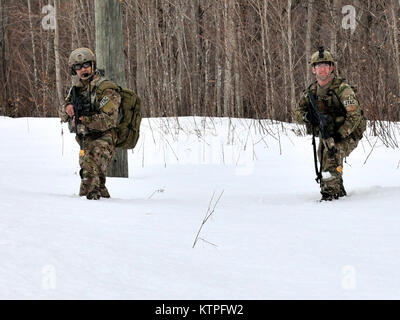 FORT DRUM, NY- membres du 274e Escadron d'opérations d'appui aérien (ASOS) de tendre vers l'objectif de formation au cours d'un exercice à Fort Drum, NY Le 14 mars 2015. Le Sgt technique. David Santiago, à gauche, et le sergent technique. Brandon Gilbert péniblement à travers la neige au cours de l'appui aérien rapproché (CAS) de la formation qui renforce leur capacité d'identifier une cible et neutraliser une menace. 30 aviateurs de la New York Air National Guard's 274e Escadron d'opérations d'appui aérien (ASOS), basé à Hancock Field Air National Guard Base formés sur l'appui aérien rapproché (CAS) ainsi que la formation pour la première fois avec tw Banque D'Images