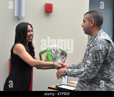 LATHAM -- New York Army National Guard Colonel John Andonie présente Mme Pennes un bouquet de fleurs et une épinglette de reconnaissance pour son soutien à son mari et la Garde Nationale de New York. Son mari, le Lieutenant-colonel Emilio Pennes a pris sa retraite après 30 ans de service lors d'une cérémonie ici, 8 nov. (US Army National Guard photo par le Sgt. Corine majeur Lombardo/libérés) Banque D'Images