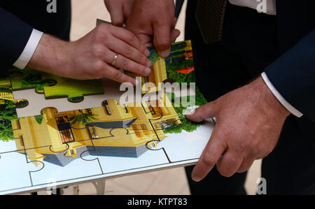 Close up mains des hommes mettre ensemble image de puzzle de chambre Banque D'Images