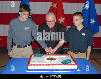 LATHAM, NY -- New York Garde Nationale recrute Zander Griffin (à gauche) et Andrew Valenza (droite) rejoindre New York à la retraite de la Garde nationale de l'Armée de l'Adjudant-chef Brian Smith (centre) pour couper un gâteau lors de cérémonies célébrant le 379e anniversaire de la Garde nationale au New York State Division des affaires militaires ici le 11 décembre, 2015. Griffin, 17 ans, et Valenza, 18, certains sont le plus jeune de New York membres nationaux et Smith a servi pendant 39 ans comme pilote d'hélicoptère. Smith fait affectés en Iraq et de la Bosnie, a pris part à des missions humanitaires en Amérique centrale, et a répondu à la Banque D'Images