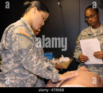 New York les soldats de la Garde nationale de l'Armée à partir de la 369e Brigade de soutien (STB) à la pratique des techniques de premiers secours sur une victime d'une blessure à la poitrine pendant le combat gareautrain (CLS) Cours de formation au Camp Smith, New York le 10 juin 2016. Des soldats de la STB 369a participé à une formation de trois jours organisé par CLS cours de la 106e RTI avant leur déploiement à venir. (New York Army National Guard photo par le Sgt. Michael Davis/libérés) Banque D'Images