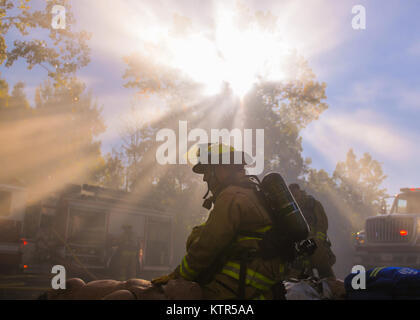 Un aviateur de la 174e Escadre attaque Fire Department s'agenouille parmi les survivants sauvés d'un incendie simulé, au cours d'un exercice tenu le Hancock Field Air National Guard Base le 15 octobre, 2016. L'exercice faisait partie d'une unité d'inspection efficacité capstone. (U.S. Photo de la Garde nationale aérienne par le sergent. Duane Morgan) Banque D'Images