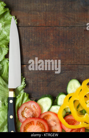 Couteau de cuisine et de légumes tranchés couché sur la surface en bois avec copie espace Banque D'Images