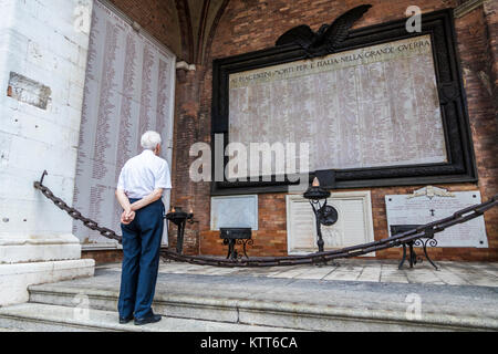 Un vieil homme se tourne vers le monde War Memorial dans le Palazzo Comunale (également appelé Palazzo Gotico) à Plaisance, Émilie-Romagne, Italie Banque D'Images