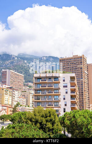 Belle vue sur la lumière du jour à hauteur des bâtiments de la ville, arbres verts et des grandes montagnes. Ciel bleu avec quelques nuages sur l'arrière-plan. Monaco, France Banque D'Images