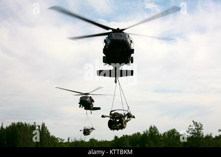 FORT DRUM, N.Y. - Deux hélicoptères UH-60 Blackhawk lors de la 42e Brigade d'aviation de combat transporte deux obusiers M119A2 d'une zone d'atterrissage lors d'un raid d'artillerie d'assaut aérien ici le 9 juin. Le raid, qui a été menée en collaboration avec les soldats de la troupe Alpha, 1er bataillon du 258e Régiment d'artillerie, 27ème Infantry Brigade Combat Team, impliqué de transporter la 4 obusiers d'une zone d'atterrissage puis les utiliser pour engager une cible ennemie. (U.S. La Garde nationale de l'armée photo par le Sgt. Alexander Recteur) Banque D'Images