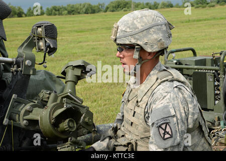 Soldat de l'armée américaine, la CPS. Michael Williamson, affecté à la batterie Bravo 2e Bataillon, 15e Régiment d'artillerie, 2e Brigade Combat Team, vise un obusier M119A2 à Fort Drum, N.Y., 14 juillet 2017. Williamson était en mission d'entraînement de l'artillerie de l'air raids. (U.S. La Garde nationale de l'armée photo de la FPC. Andrew Valenza) Banque D'Images