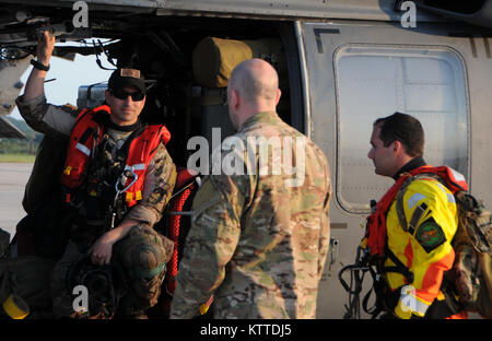 Le sergent-major de la Force aérienne. Juan Salgado, Air Force Master Sgt. Joseph Spadevechia Niveau supérieur de la Force aérienne et d'un membre de la John J. Kosequat, toutes les pararescuemen du 103e Escadron de sauvetage Sauvetage de la 106e Escadre assigné à la Garde Nationale de New York réunit à la porte d'un HH-60 hélicoptère Pavehawk à Fort Hood, au Texas, le 28 août 2017. Salgado et Kosequat est revenu de sa mission quotidienne qui a contribué à sauver 255 personnes et deux chiens, à Houston. (U.S. Photo de la Garde nationale par Daniel H. Farrell) Banque D'Images