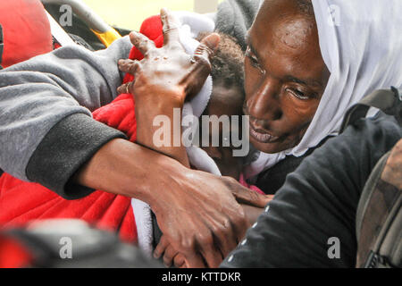 Une femme d'un enfant de la dorlote cabine d'un HH-60 Pave Hawk helicopter, exploité par les aviateurs de la 106e Escadre de sauvetage assigné à la Garde nationale aérienne de New York, plus de Beaumont, le 30 août 2017. Les membres du 106e tiré de la famille jusqu'à partir de la crue des eaux en face de leur maison et les ont chuté en toute sécurité à une personne évacuée du point de collecte. (U.S. Air National Guard photo par Daniel H. Farrell) Banque D'Images