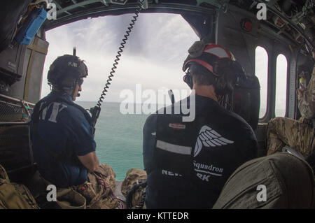 Pararescuemen donnent à la vue de dessus de l'eau sur le chemin de Saint Thomas. Aviateurs de la New York Air National Guard's 106th Rescue Wing voler plus de Saint-Thomas et Saint-John dans un HH-60 Pave Hawk helicopter le 10 septembre, 2017. Ils cherchent des personnes qui ont besoin d'une aide indispensable à la suite de l'ouragan l'Irma. Banque D'Images