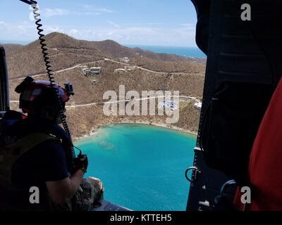 L'enquête sur la destruction de l'équipage de l'hélicoptère au-dessus des îles Vierges américaines. Aviateurs de la New York Air National Guard's 106th Rescue Wing voler plus de Saint-Thomas et Saint-John dans un HH-60 Pave Hawk helicopter le 10 septembre, 2017. Ils cherchent des personnes qui ont besoin d'une aide indispensable à la suite de l'ouragan l'Irma. Banque D'Images