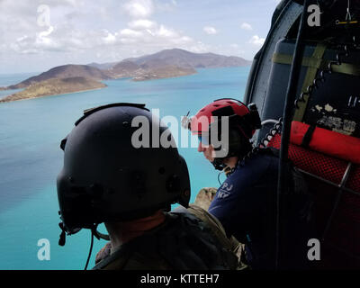 L'enquête sur la destruction de l'équipage de l'hélicoptère au-dessus des îles Vierges américaines. Aviateurs de la New York Air National Guard's 106th Rescue Wing voler plus de Saint-Thomas et Saint-John dans un HH-60 Pave Hawk helicopter le 10 septembre, 2017. Ils cherchent des personnes qui ont besoin d'une aide indispensable à la suite de l'ouragan l'Irma. Banque D'Images