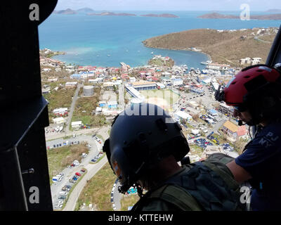 L'enquête sur la destruction de l'équipage de l'hélicoptère au-dessus des îles Vierges américaines. Aviateurs de la New York Air National Guard's 106th Rescue Wing voler plus de Saint-Thomas et Saint-John dans un HH-60 Pave Hawk helicopter le 10 septembre, 2017. Ils cherchent des personnes qui ont besoin d'une aide indispensable à la suite de l'ouragan l'Irma. Banque D'Images