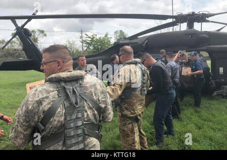 L'État de New York, des policiers et des soldats affectés à la Garde Nationale de New York 3e bataillon du 142e, matériel de l'aide à décharger l'Aviation Bayamon, Puerto Rico le 9 octobre 2017.Le bataillon déployé 60 soldats et 4 hélicoptères UH-60 à Puerto Rico pour aider à l'Ouragan Maria post- les opérations de secours. Banque D'Images