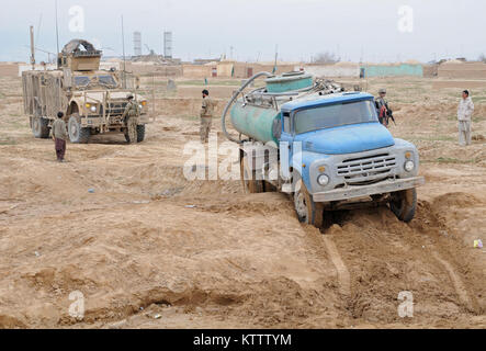 Sécurité personnelle des soldats affectés au Siège, la compagnie d'infanterie de la 37e Brigade Combat Team, sur le chemin de retour d'une mission, s'arrêter pour aider un agriculteur afghan local tirer son chariot hors de la vase près de Mazar-e-Sharif, en Afghanistan, le 10 mars 2012. La 37e IBCT est déployé en Afghanistan dans le cadre de l'opération Enduring Freedom. 37e (IBCT photo par le Sgt. Kimberly Agneau) (Sortie) Banque D'Images