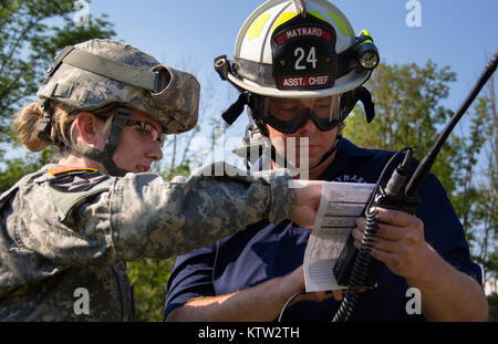 MARCY, NY- Sgt. Kayli Engert de la 401st Battation des affaires civiles, l'armée des États-Unis, demande à un membre du service de pompiers volontaires de Maynard comment faire appel à une ligne 9 en attente d'une demande d'évacuation médicale UH-60 Blackhawk de F Co., NY 1-169 Army National Guard. Photo de Harley SPC Jelis, CABINE, NYARNG HHC 42e Banque D'Images