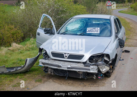 Dépouillé et vandalisée voiture abandonnée dans un chemin de campagne avec conseil sait autocollant à Surrey, Royaume-Uni de pare-brise Banque D'Images