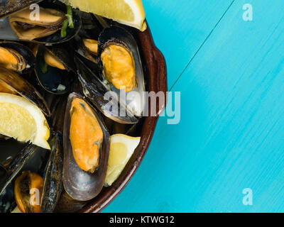Les moules cultivées de corde dans une sauce à l'ail et l'échalote avec des tranches de citron