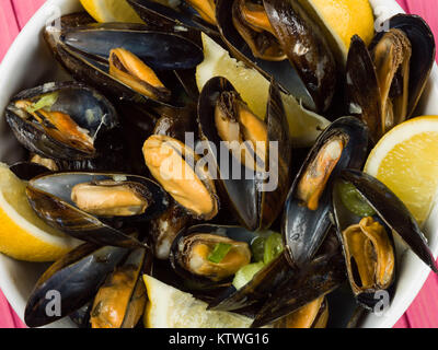 Les moules cultivées de corde dans une sauce à l'ail et l'échalote avec des tranches de citron
