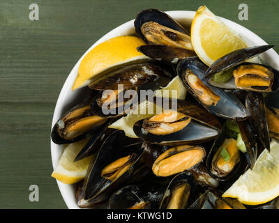 Les moules cultivées de corde dans une sauce à l'ail et l'échalote avec des tranches de citron