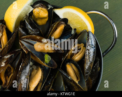 Les moules cultivées de corde dans une sauce à l'ail et l'échalote avec des tranches de citron
