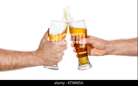 Les mains des hommes avec verre de bière toasting créer splash isolé sur fond blanc. Paire de verres à bière faire des toasts. Bières en hausse. Cheers Banque D'Images