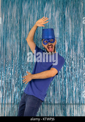 L'homme fait un crazy poser et c'est criant. Le port de vêtements est brésilien bleu : top hat et masque. Carnaval, Mardi Gras, la veille du Nouvel An. Style, mystère. Banque D'Images