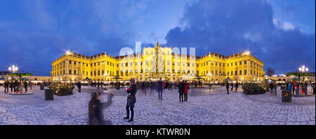 Vue panoramique du palais de Schönbrunn en période de Noël avec fairy lights decorated Christmas Tree et marché à l'heure bleu crépuscule de l'Avent. Banque D'Images