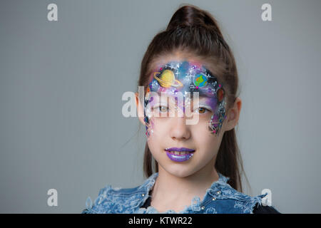 Portrait d'une magnifique petite fille Kazakh sur fond gris avec un visage peint Banque D'Images