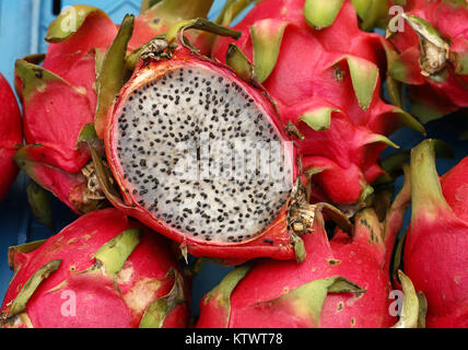 Close up plusieurs rouge mûre pitaya ou fruit du dragon pitaya blanc avec une coupe la moitié de la section transversale sur market stall, high angle view Banque D'Images