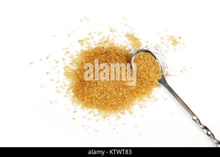 Cuillère en métal plein de sucre de canne brun avec pincée de sucre renversé autour d'isolé sur fond blanc, Close up, augmentation de la vue supérieure Banque D'Images