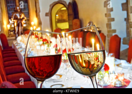 Table de Noël verres à vin rouge et blanc aux chandelles Des verres de dégustation qui enchantent « Cheers » au premier plan d'un luxe formel dégustation de table de fête aux chandelles Banque D'Images