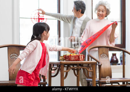 Famille heureuse décorant leur maison pour le Nouvel An chinois Banque D'Images