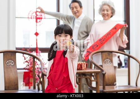 Happy little girl holding a chocolate coin Banque D'Images