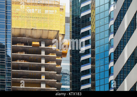 Bâtiment moderne en construction, sols en béton. Fragment de façade avec des structures d'échafaudage Banque D'Images